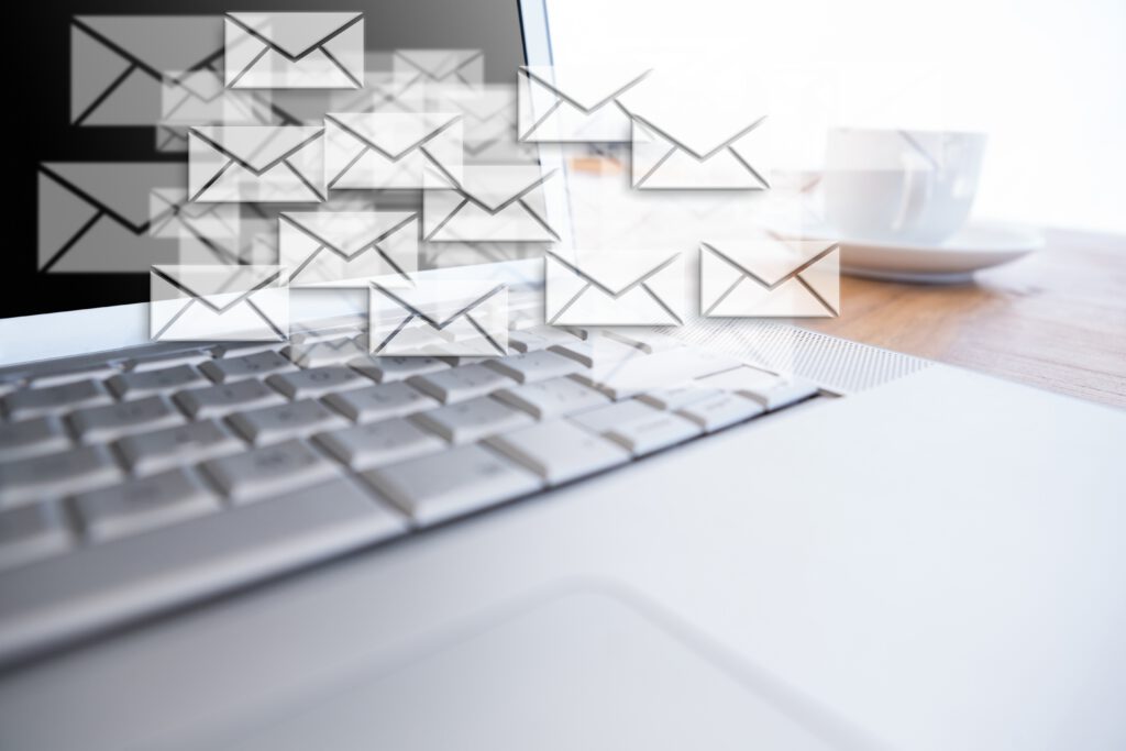 Email Symbole schweben vor einem Bildschirm