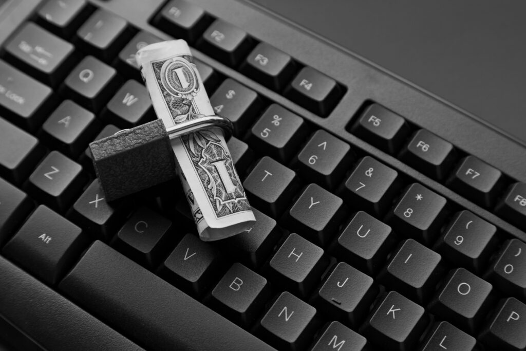 Dollarnote in einem Schloss auf einer Laptop Tastatur